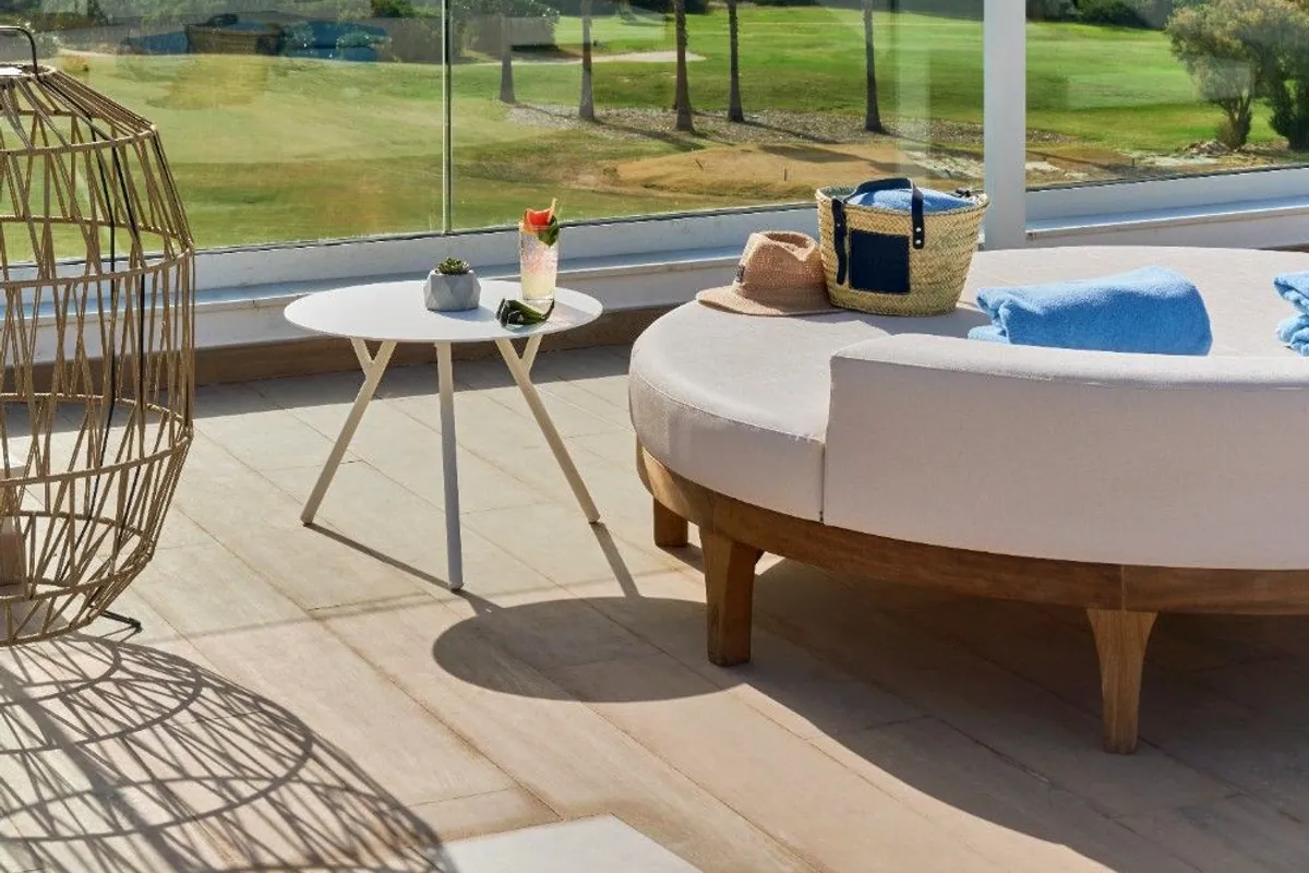 Terraza de Amàre Sancti Petri con cama balinesa y vistas al mar y a las palmeras