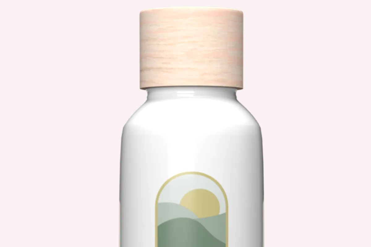 Frasco blanco del Annue Body Elixir con tapón de madera sobre fondo negro