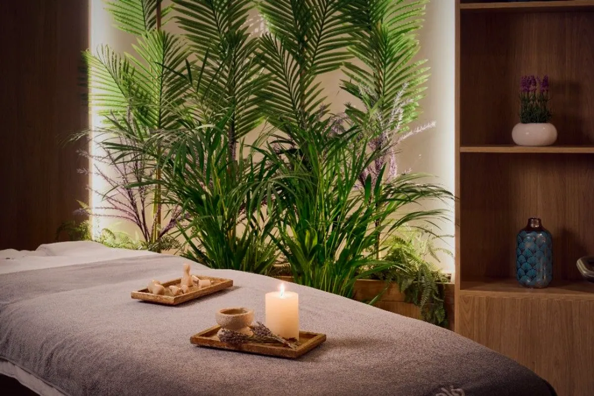 Camilla de masaje con velas y plantas en el spa del hotel