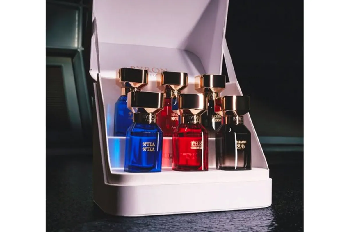 Estuche blanco abierto con varios frascos de Byron Parfums en azul, rojo y negro