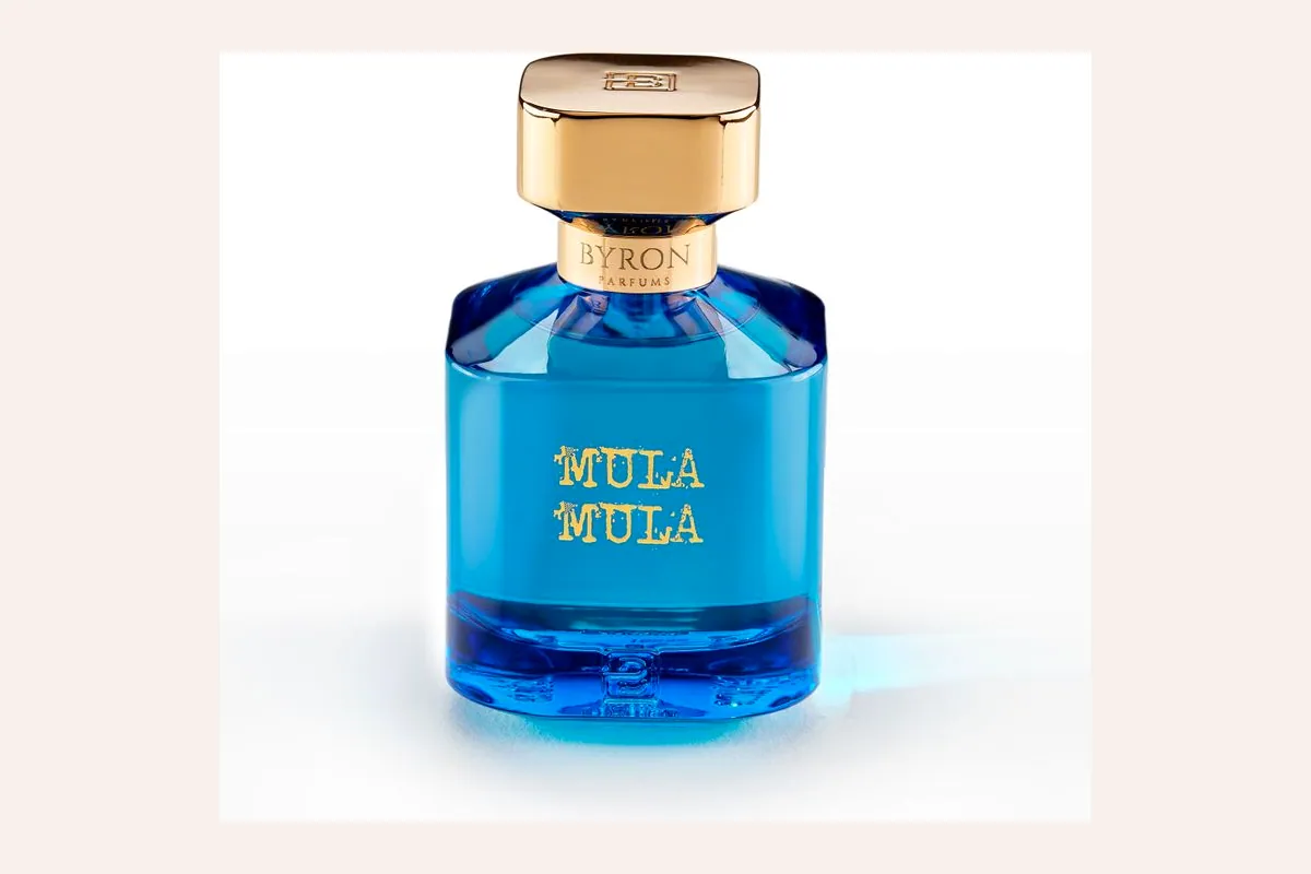 Frasco azul de Byron Parfums Mula Mula con tapón dorado sobre fondo blanco