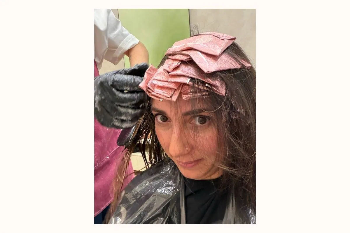 Papeles rosas de las mechas microlights colocados en el pelo durante el proceso
