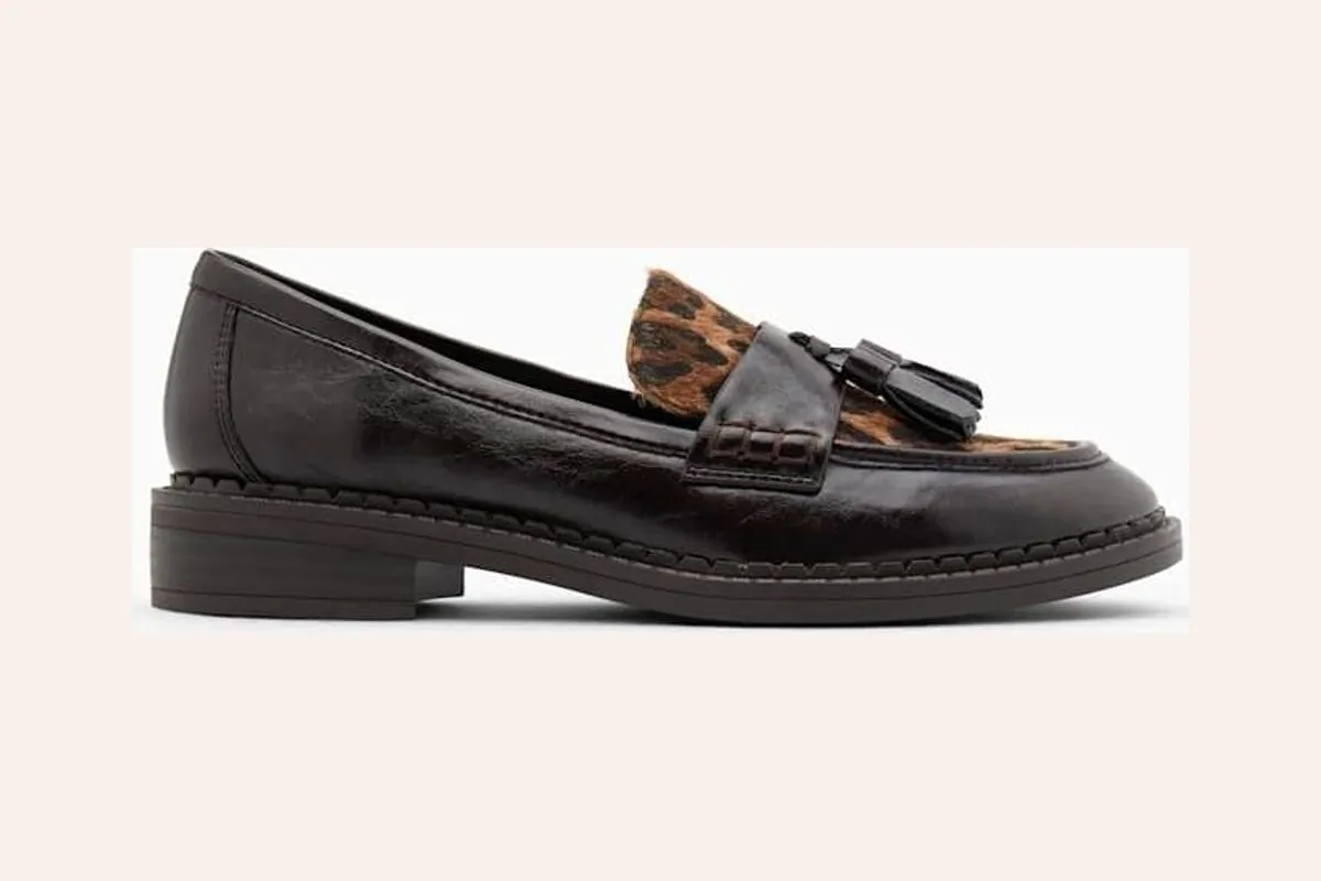 Mocasín negro con detalle de animal print y borlas