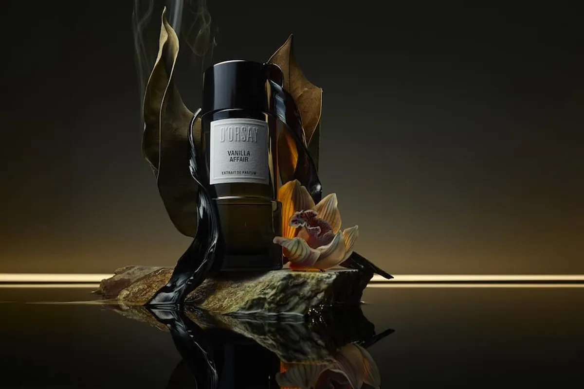 Frasco del perfume D'Orsay Vanilla Affair sobre una piedra con hojas secas y humo