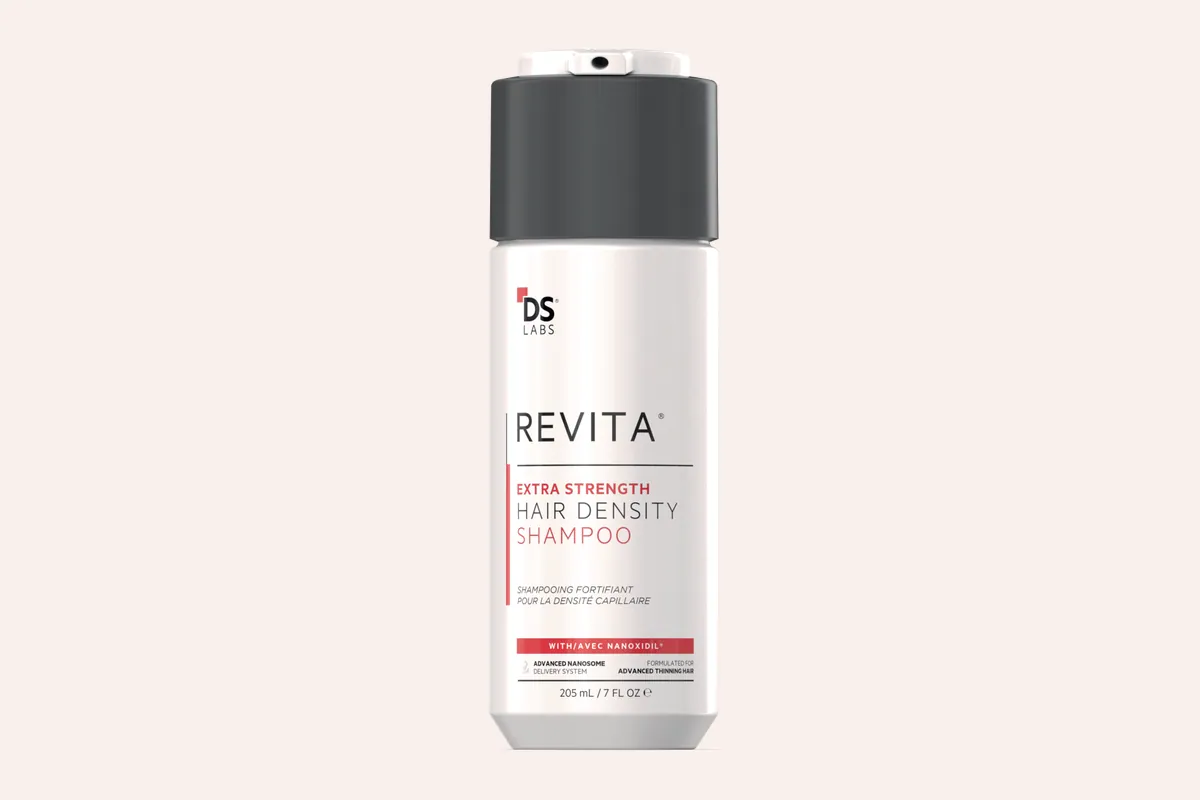 Bote blanco del champú Revita Extra Strength de DS Labs sobre fondo negro