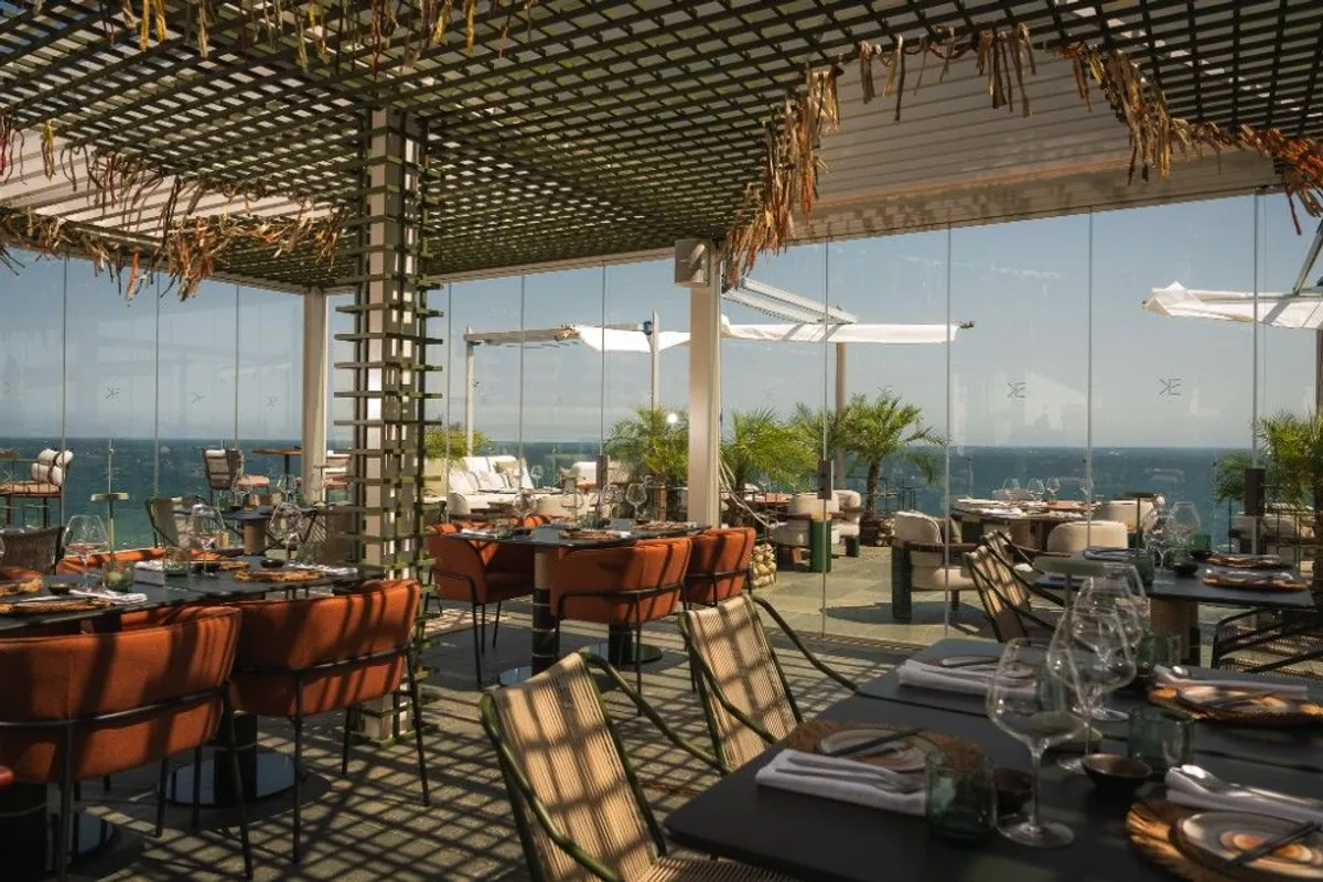 Comedor del restaurante Kena by Akiro con sillas naranjas y vistas al mar