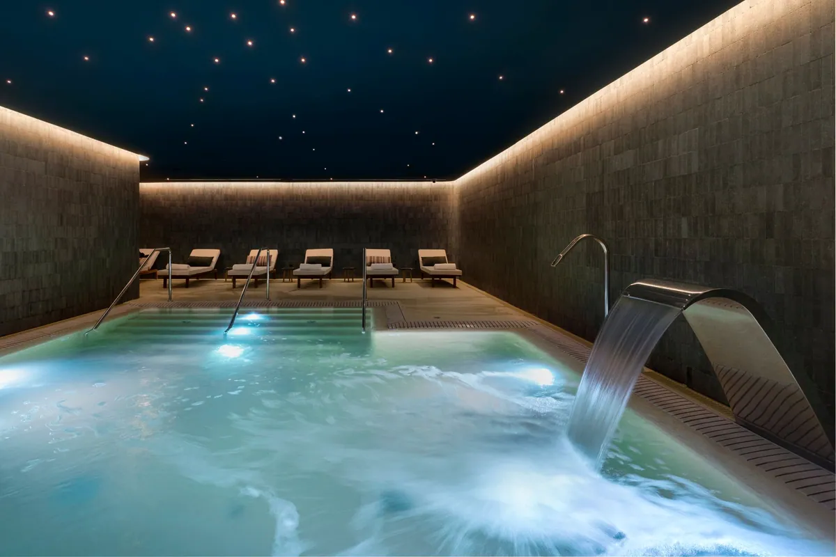 Piscina de hidroterapia con cascada y techo de luces en el spa de El Fuerte Marbella