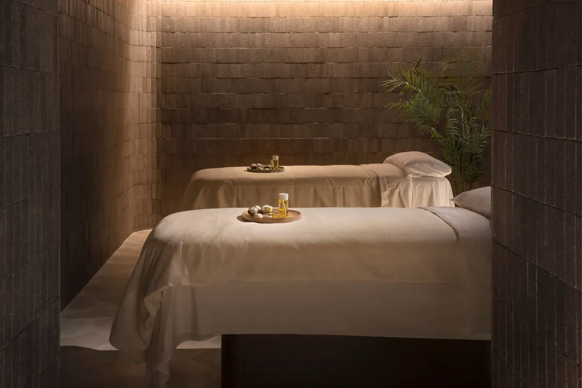 Sala con dos camillas de masaje y luz cálida en el spa de El Fuerte Marbella