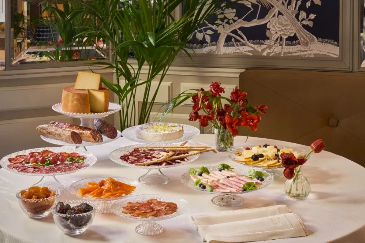 Mesa de desayuno del Heritage Madrid con quesos, embutidos y fruta