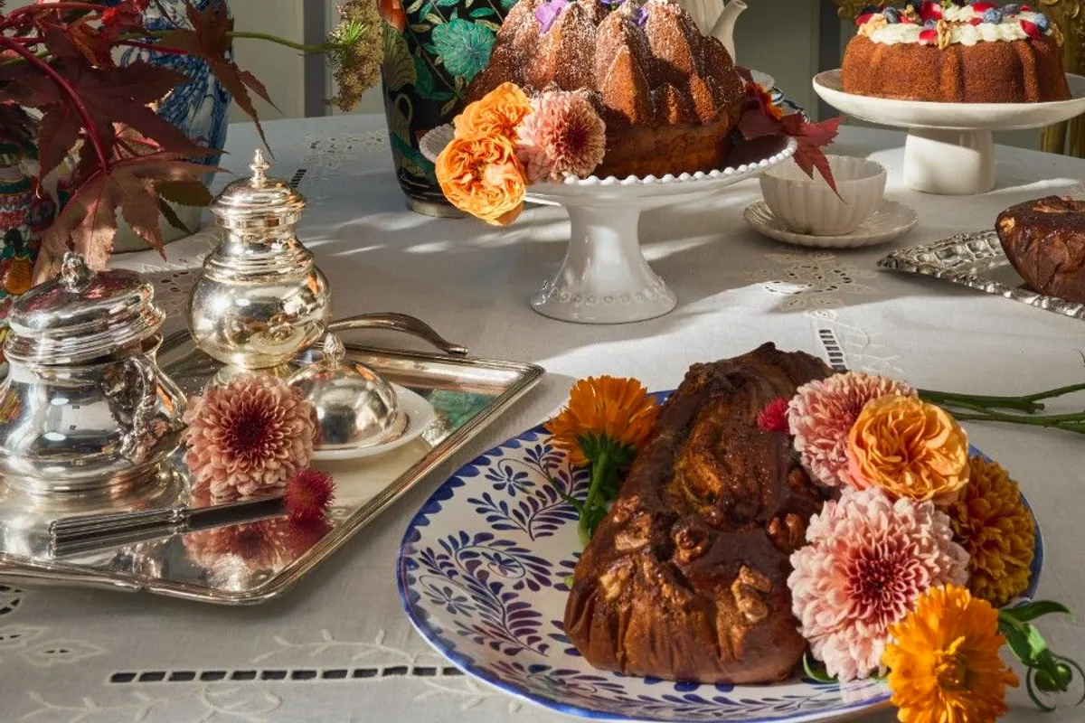 Mesa de merienda con bizcochos artesanos, flores y servicio de plata