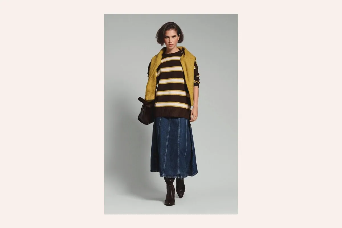 Jersey de rayas marrones y amarillas con falda vaquera midi y botas de Lefties