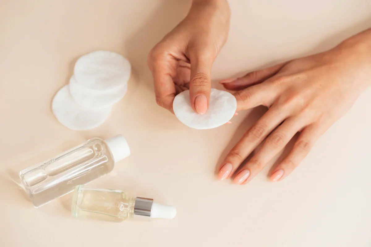 Manos con las uñas cuidadas y utensilios de manicura