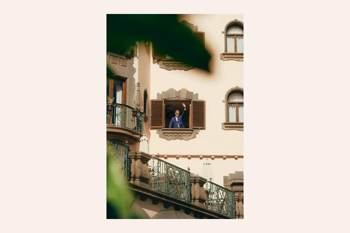 Hombre saludando desde una ventana de la fachada del hotel Santa Catalina