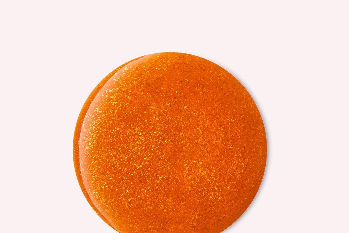 Bomba de baño redonda naranja con purpurina dorada de Lush