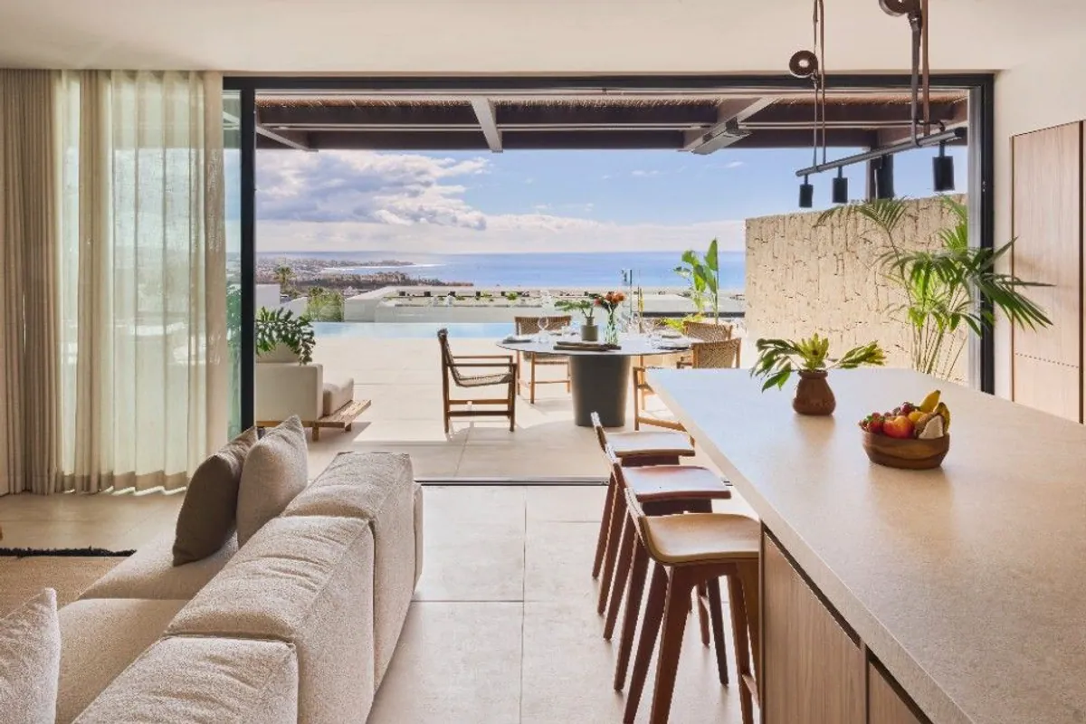 Salón y cocina abiertos a la terraza con vistas al mar en Tenerife