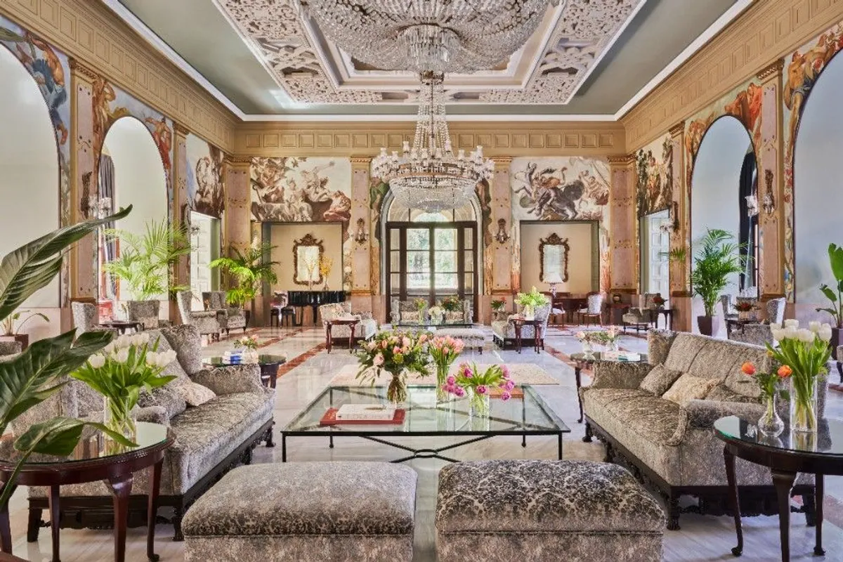 Salón del hotel Santa Catalina con frescos, lámpara de araña y sofás tapizados