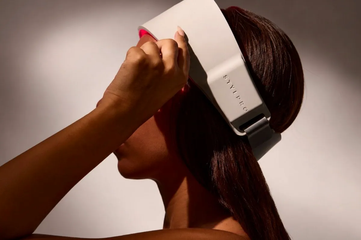 Mujer de espaldas colocándose la diadema de luz roja STYLPRO en la cabeza