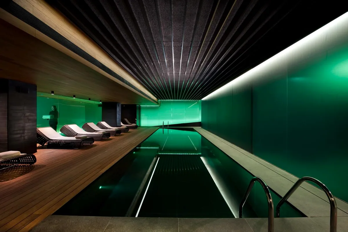 Piscina del spa del Mandarin Oriental de Barcelona con luz verde y tumbonas