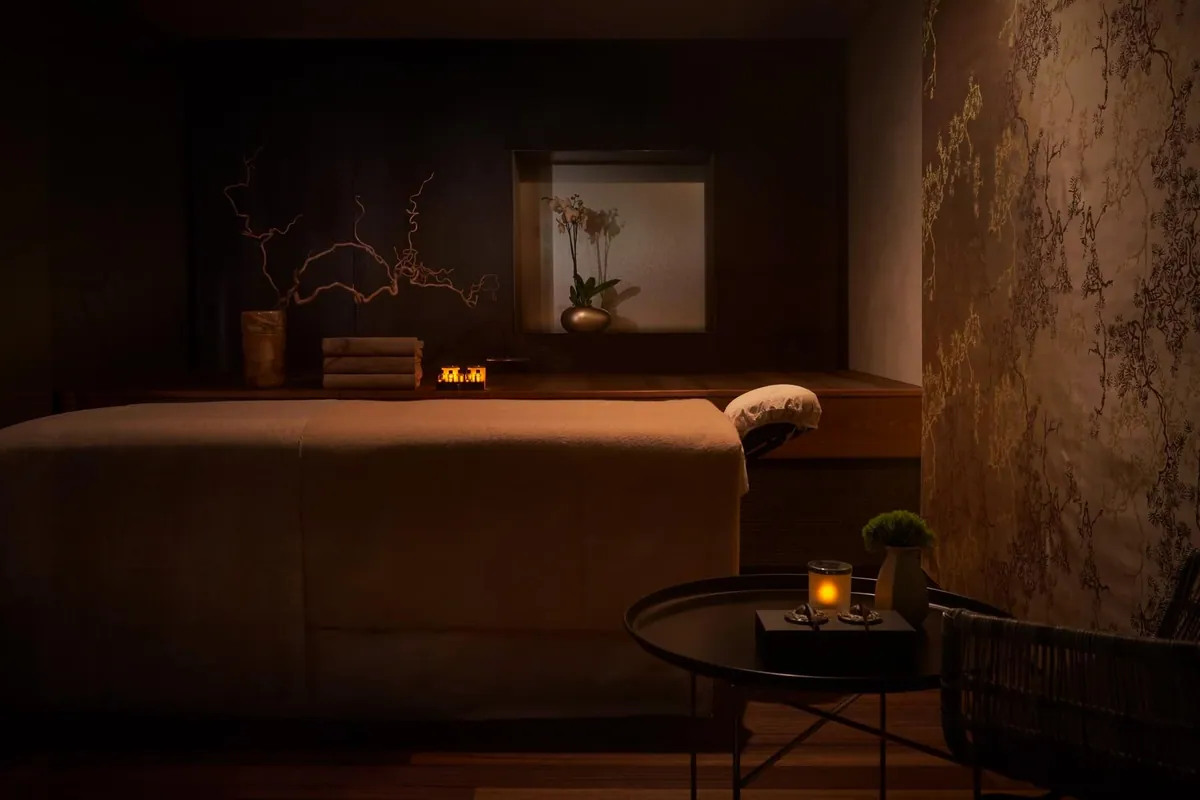 Cabina de tratamiento con camilla y velas en el spa del Mandarin Oriental de Barcelona