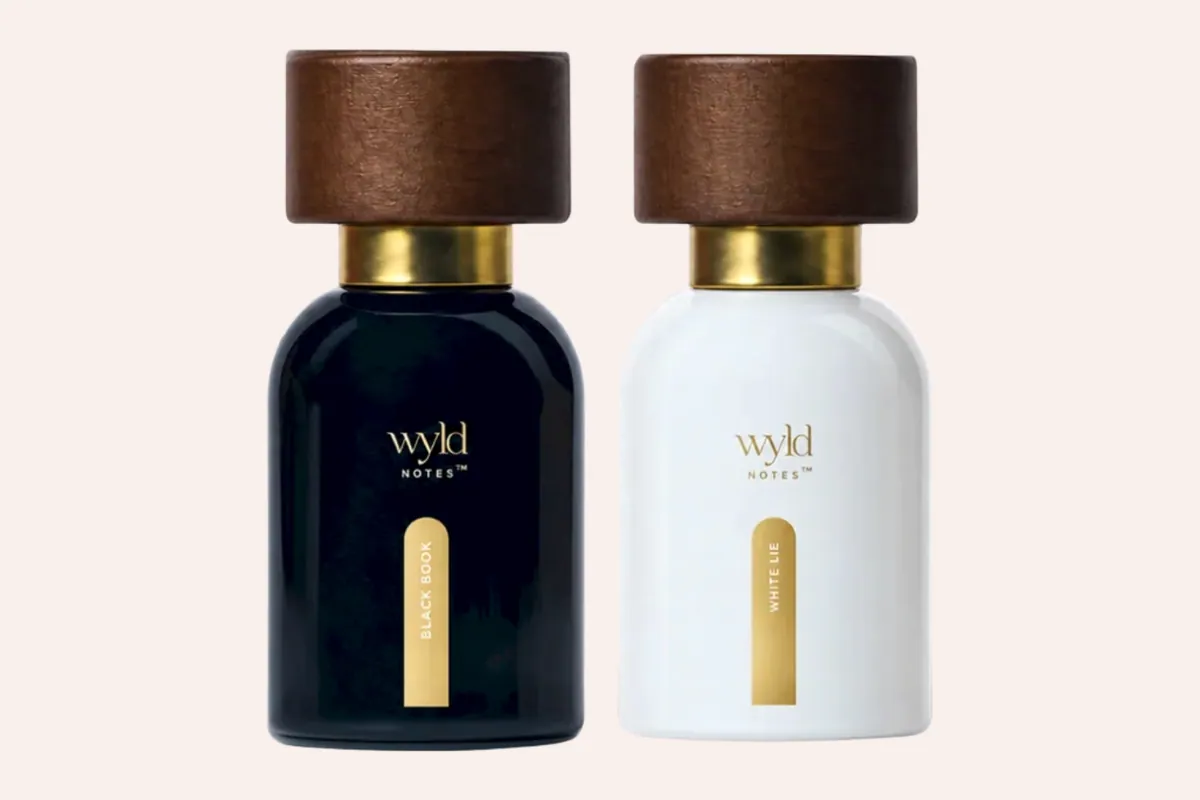 Perfumes Black Book y White Lie de Wyld Notes uno al lado del otro sobre fondo negro